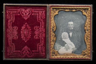 Seated man holding a baby daguerreotype, undated